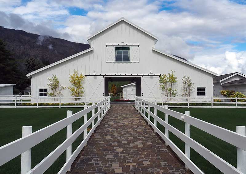 Finished project featuring a barn with beautiful landscaping and paver walkway